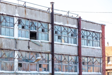 large industrial building abandoned of factory with broken windows at sunny dayの写真素材