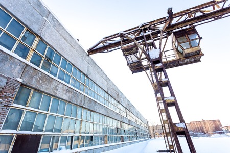 large industrial building in abandoned factory area with rusty lift at sunny dayの写真素材