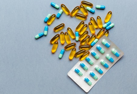 colorful medical pills isolated on gray background and pack of tabletsの写真素材