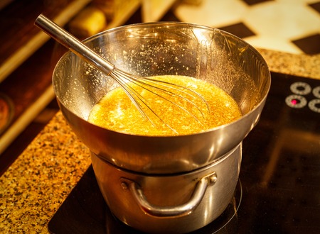 whipping butter cream in metal bowl with whiskの写真素材