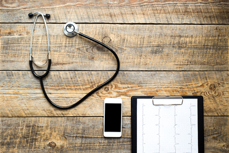 empty doctor workplace with a stethoscope and glasses view from above at wooden tableの写真素材