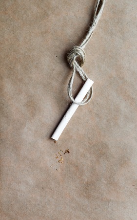 concept hangman's knot on paper background with cigarette close upの写真素材