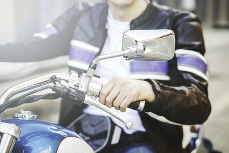men's hands on wheel motorcycle close up