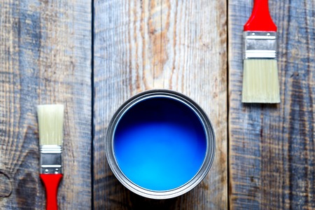 painting at home with can of blue paint and two brush on wooden background top viewの写真素材