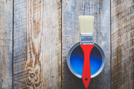 jar with blue paint and brush  with red grip on the wooden background top viewの写真素材