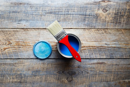 open jar with blue paint and brush  with red grip on the wooden background top view close upの写真素材
