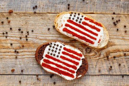 Two sandwiches with image of american flag on wooden table, top view.