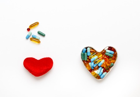 red plush heart and pills in shape of heart top view isolatedの写真素材