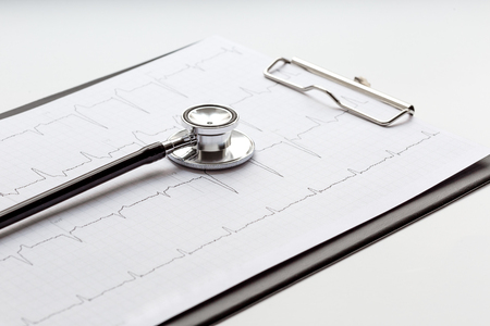 new stethoscope on a white background with cardiogram close upの写真素材