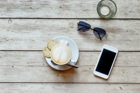 Breakfast with coffee and a telephone on the wooden table top viewの写真素材