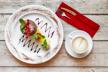 Sweet dessert with coffee on the wooden table top viewの写真素材