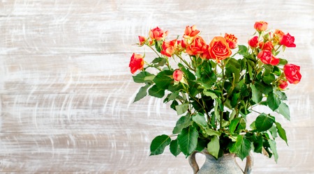 bouquet of red tea roses on wooden backgroundの写真素材