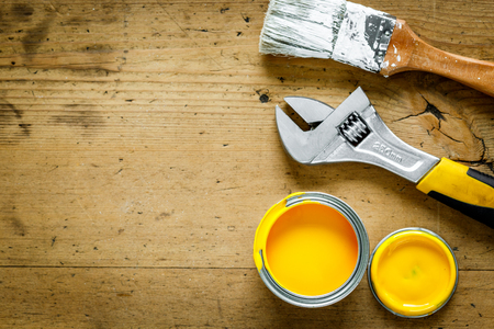 construction tools on a wooden table with yellow paint top viewの写真素材