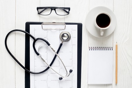 empty doctor workplace with a stethoscope and glasses view from above at wooden tableの写真素材