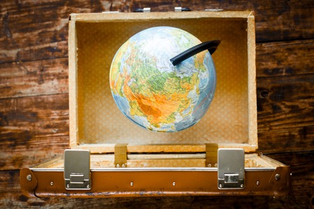 concept - time to travel suitcase, globe on wooden tableの写真素材