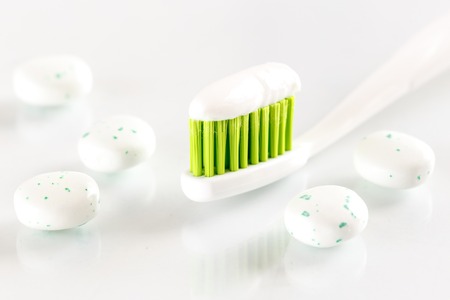 sqweezed green toothbrush on white background with bubble gums - concept for toothcare