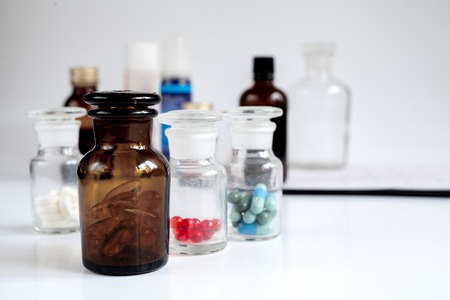 glass jars of pills - home first aid kit on white backgroundの写真素材