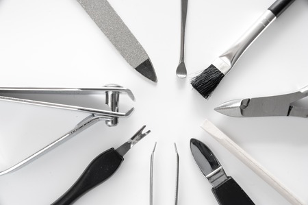 set of metallic manicure tools macro on white backround