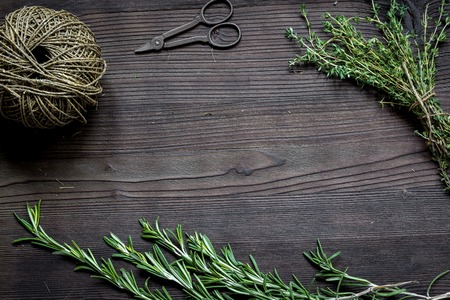fresh herb frame of rosemary and thyme on dark wooden background top viewの写真素材