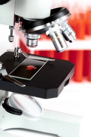 close up macro microscope with blood sample, tubes on white background.