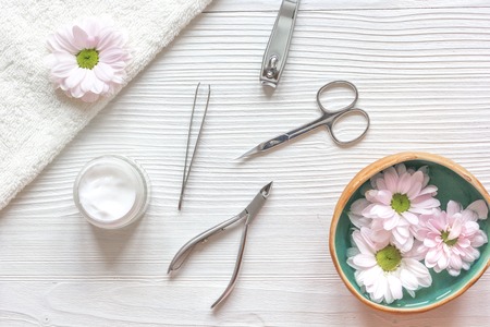 oil and cream for nail care in spa on wooden background top view