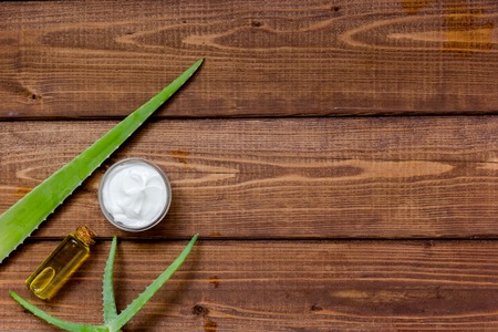 White beauty cream in jar with aloe vera on wooden background top viewの写真素材