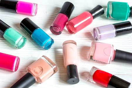 bottles of colored nail polish on wooden background.の写真素材