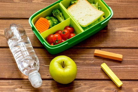 lunch box for kid with fresh vegetables on wooden background.の写真素材