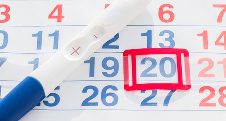 Positive pregnancy test with calendar close up top viewの写真素材