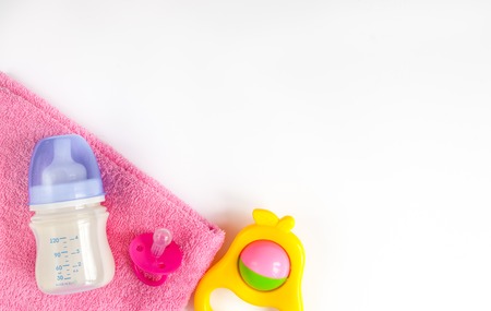 baby bottle with milk and towel on white background top view
