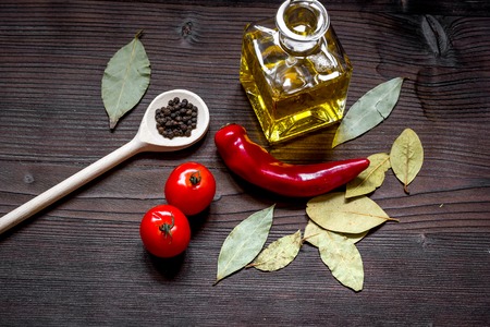 jar with oil and tomatoes, spices on dark wooden background top viewの写真素材