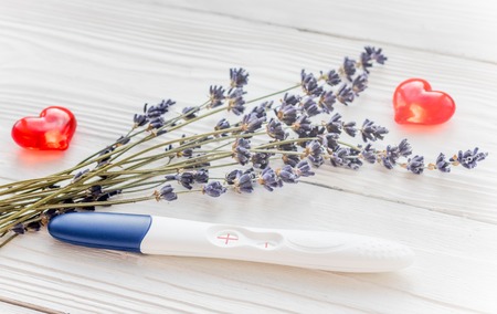 Positive pregnancy test with lavender on wooden background.の写真素材