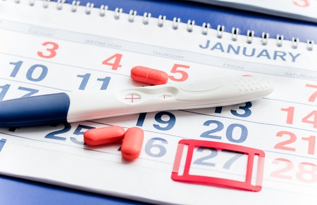 Positive pregnancy test with calendar close up top viewの写真素材