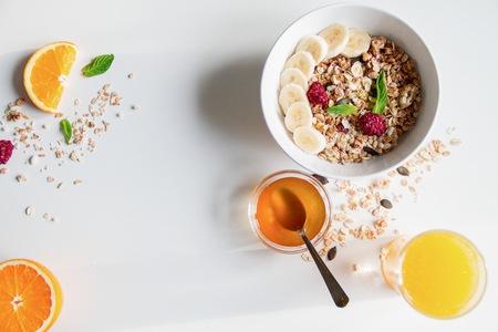 Breakfast with oatmeal and orange juice on white background top viewの写真素材