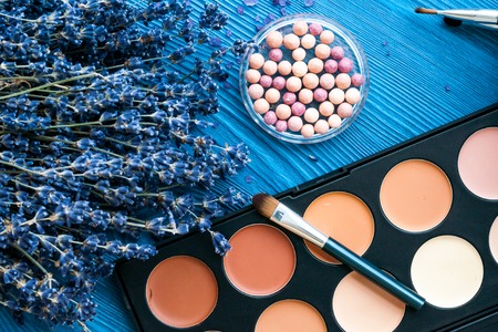 cosmetic palette and lavender flowers on wooden background close upの写真素材