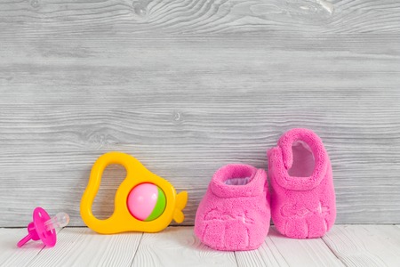 pink booties on wooden background close up