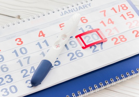 Positive pregnancy test with calendar close up top viewの写真素材