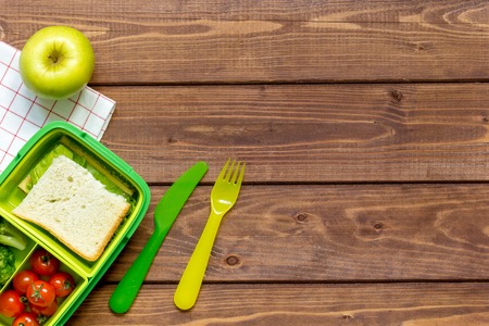 green lunch box for kid on dark wooden background top view mock upの写真素材