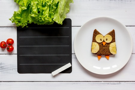 kids menu owl shaped sandwich with tomato place for text top view at wooden backgroundの写真素材