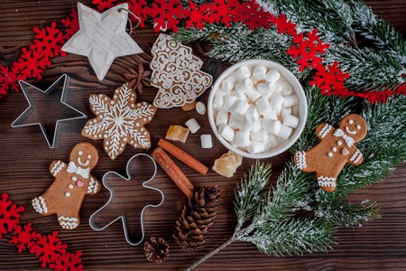 Christmas gingerbread, spruce branches on dark wooden background top view.