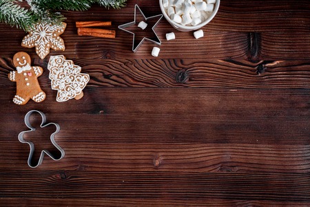 Christmas gingerbread, spruce branches on dark wooden background top view.