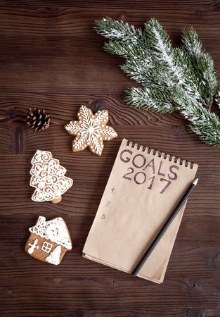 notebook and goals for new 2017 year on dark wooden background top view