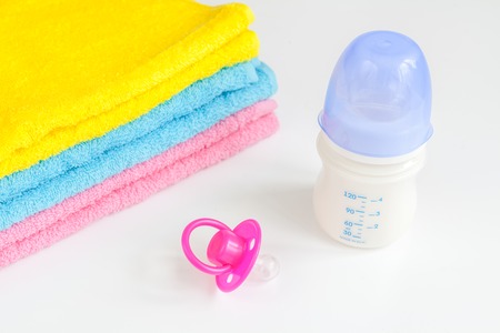 baby bottle with milk and towel on white background close up