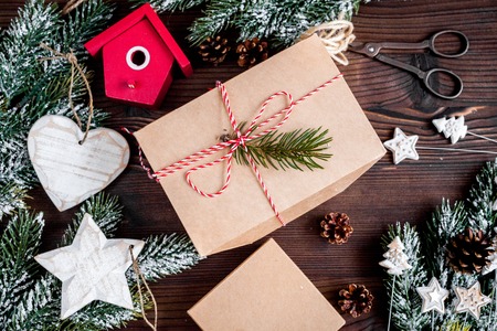 gifts boxes with fir branches on dark wooden background top view.