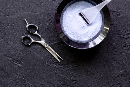 hair dye with brush on dark background top view.