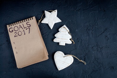 notebook and goals for new 2017 year on dark background top view