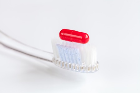concept toothache with toothbrush and tablet at white background close upの写真素材