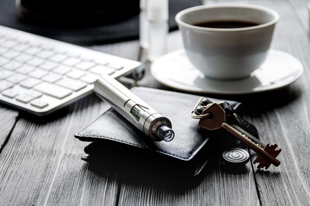 electronic cigarettes and mens accessories on dark wooden background close upの写真素材