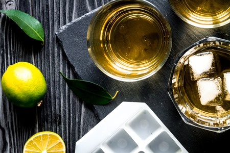 glass of scotch on dark wooden background top view close upの写真素材
