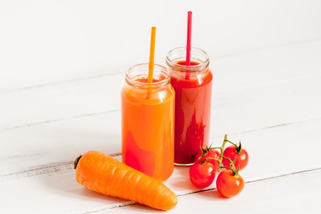 Fresh detox juices in glass bottles on white background.の写真素材
